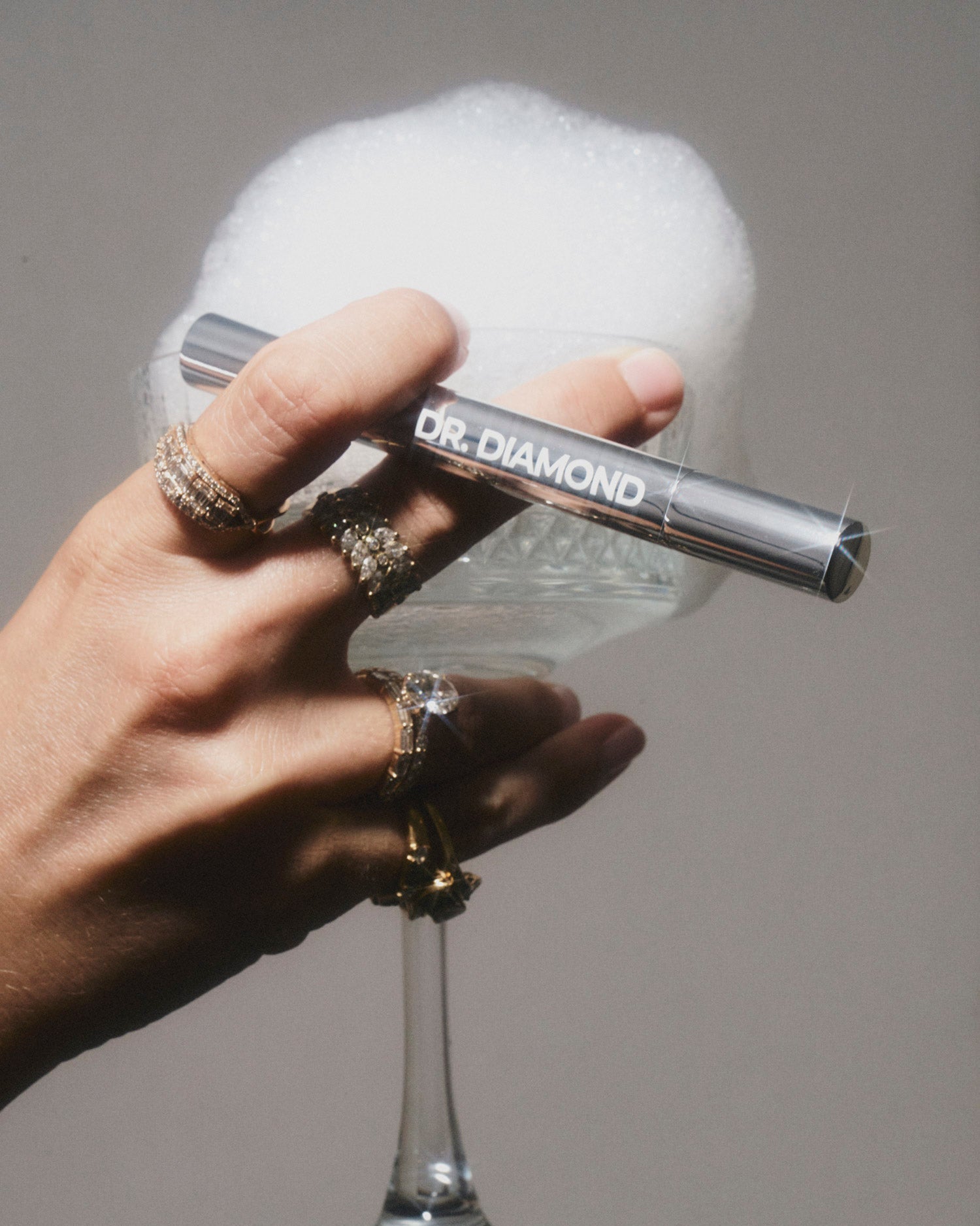 silverdiamondandjewellerycleaningpeninhandwithdiamondsandcup